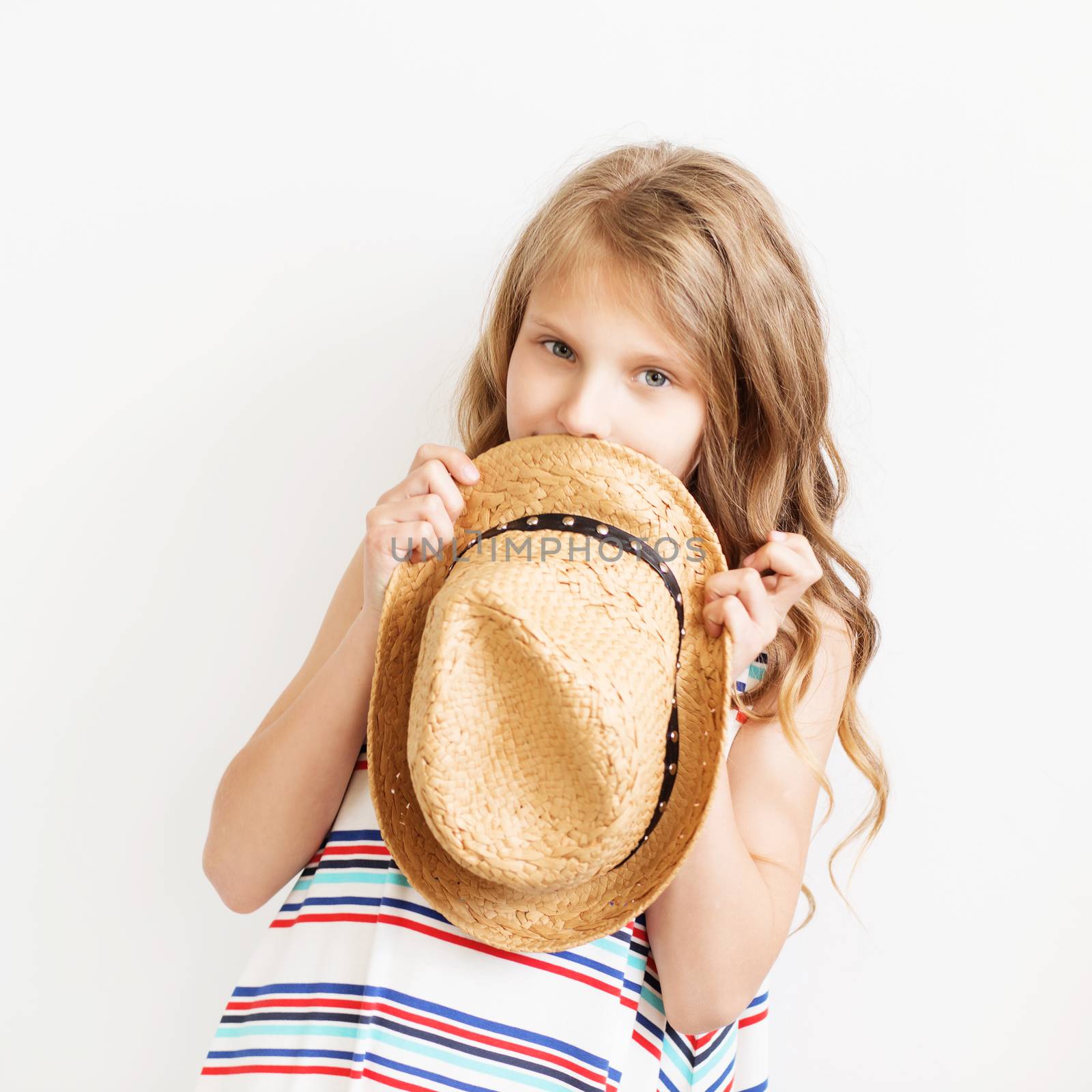 Lovely little girl with straw hat against a white background. by natazhekova