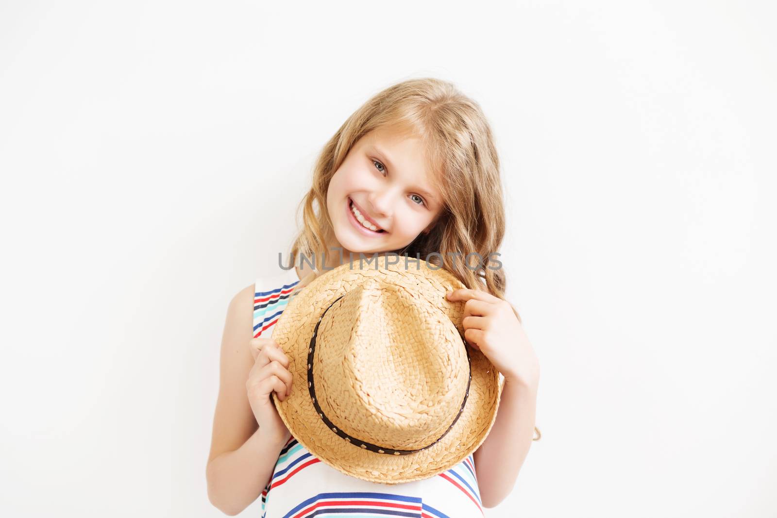 Lovely little girl with straw hat against a white background. Happy kids