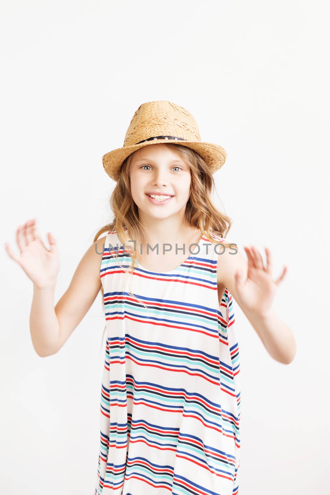 Lovely little girl with straw hat against a white background. Happy kids