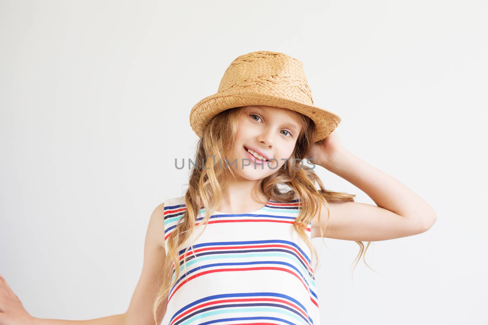 Lovely little girl with straw hat against a white background. Happy kids