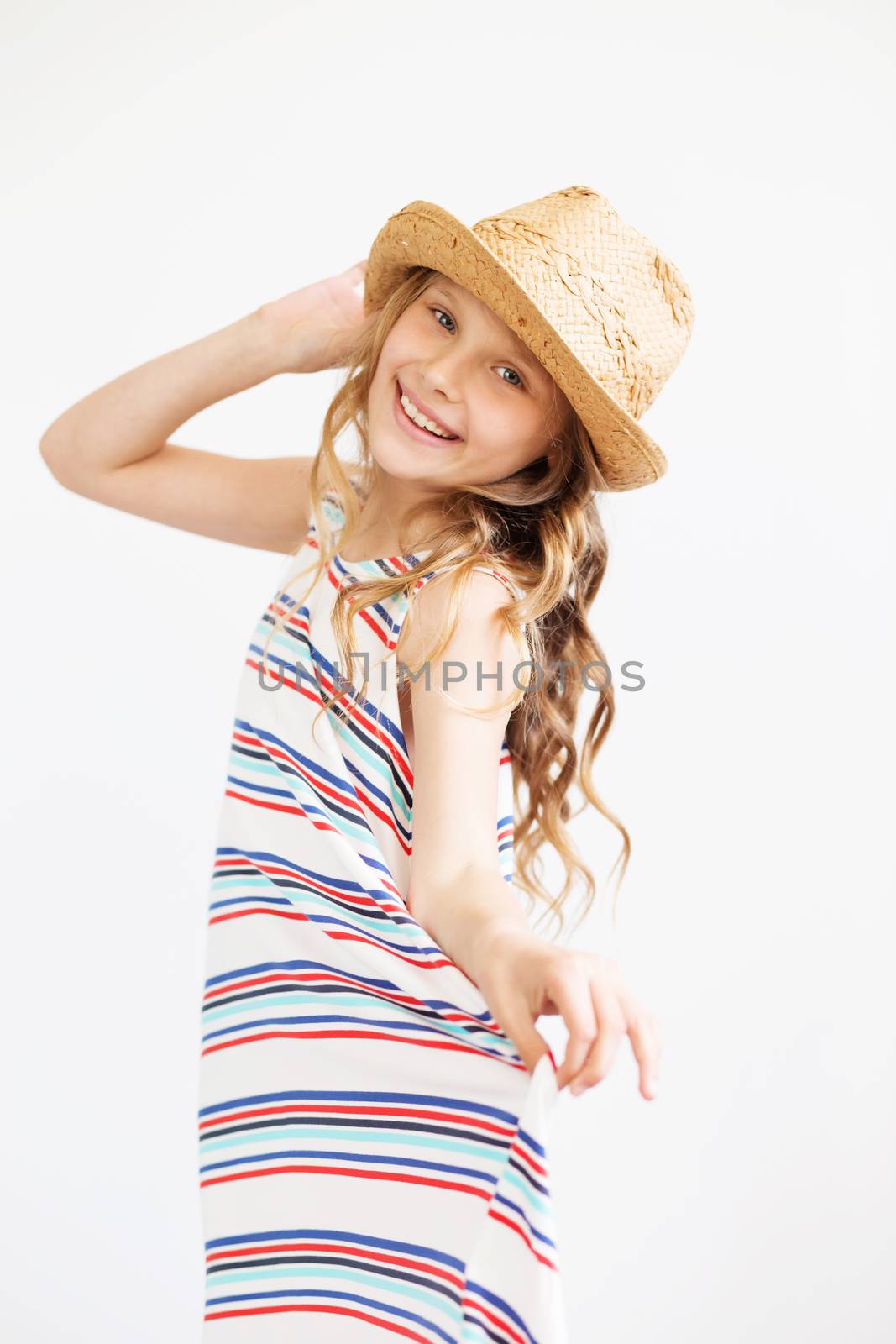 Lovely little girl with straw hat against a white background. Happy kids