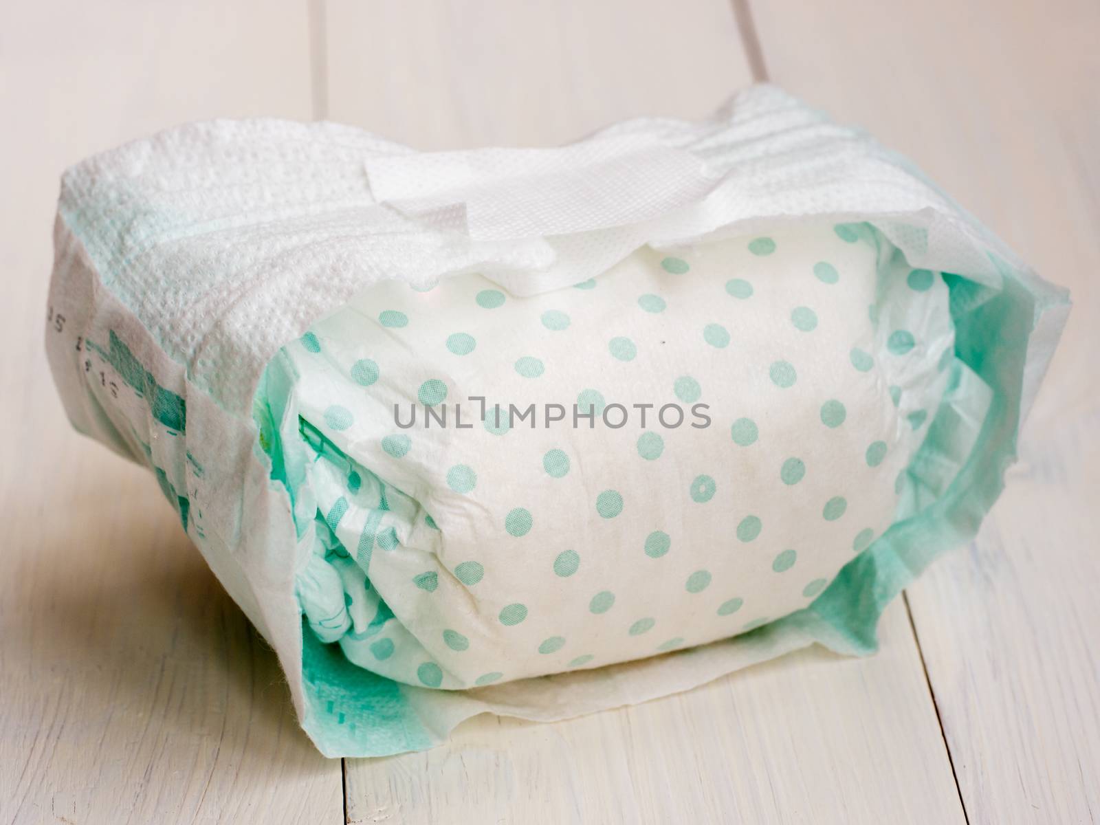 dirty diaper on white wooden background, selective focus