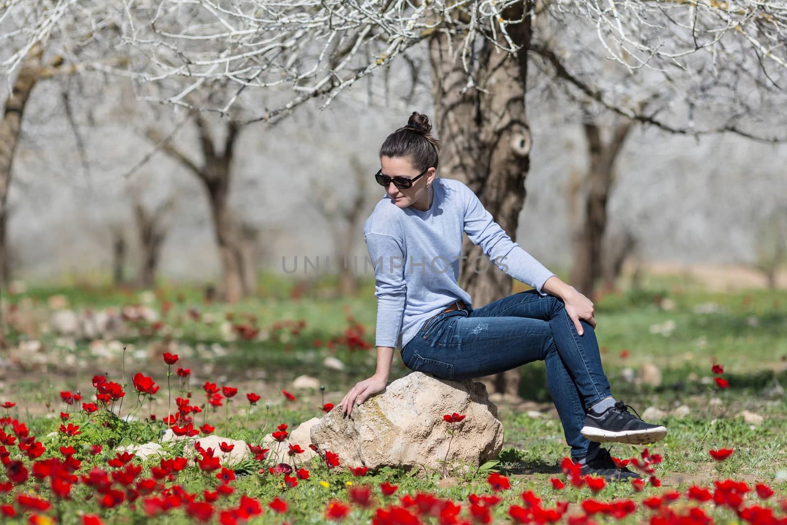 woman relaxing in a field with red poppies