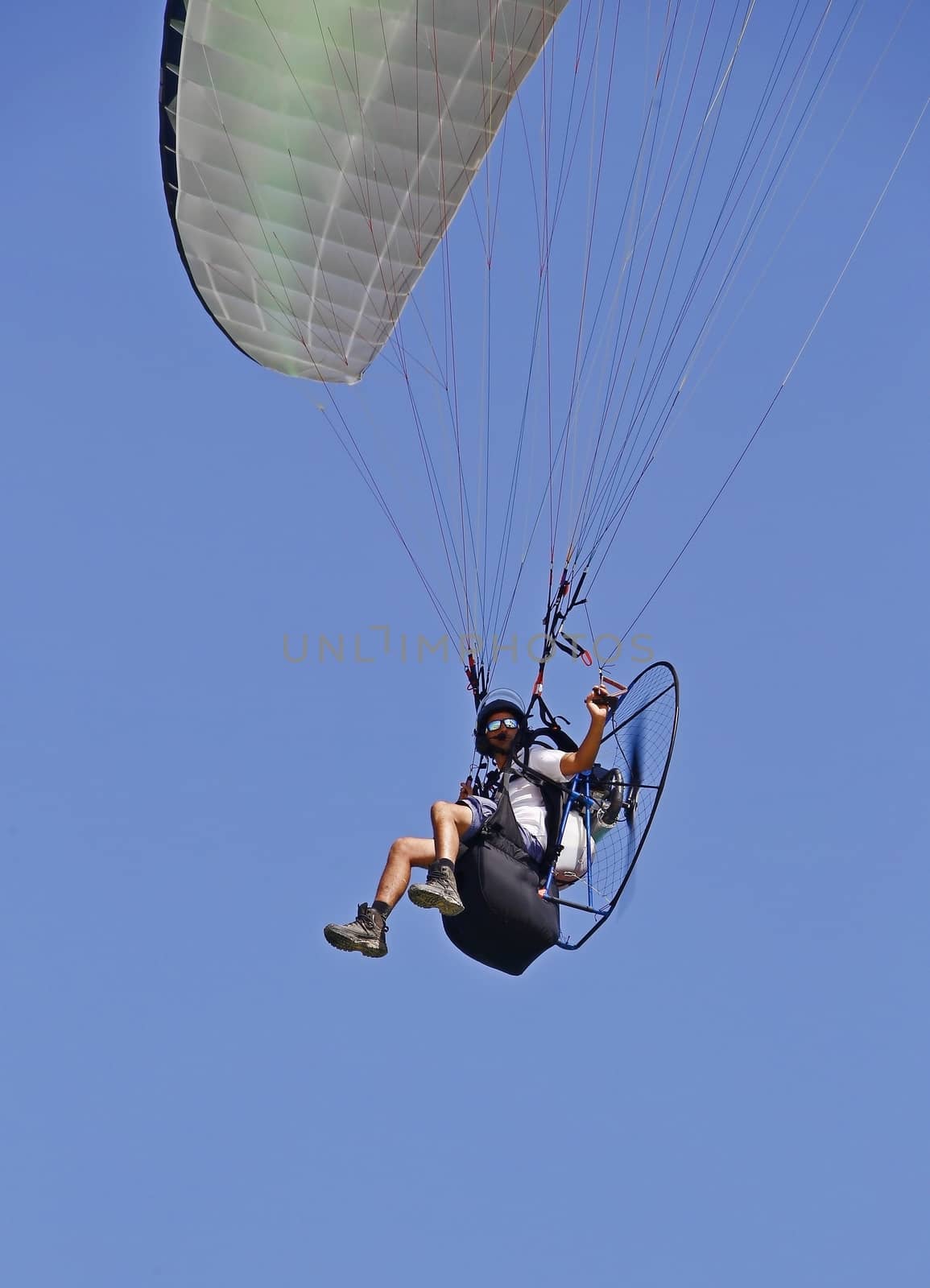 man flying on a parachute blue sky background