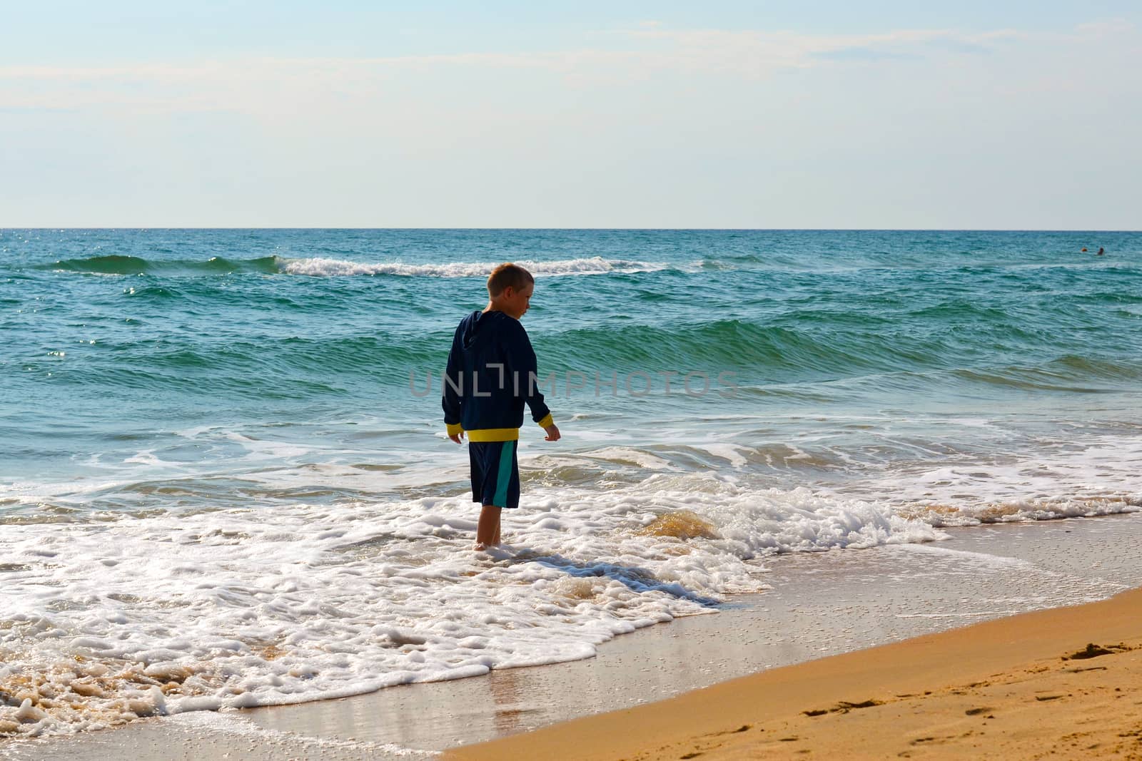 The teenage boy goes on the seashore. by veronka72