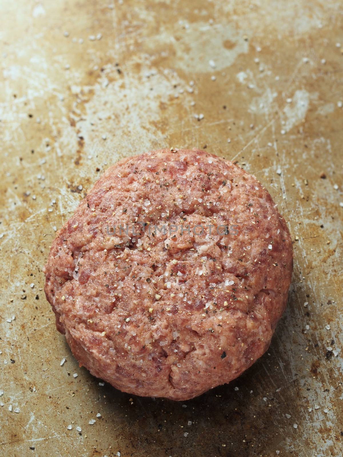 close up of rustic uncooked seasoned hamburger patty