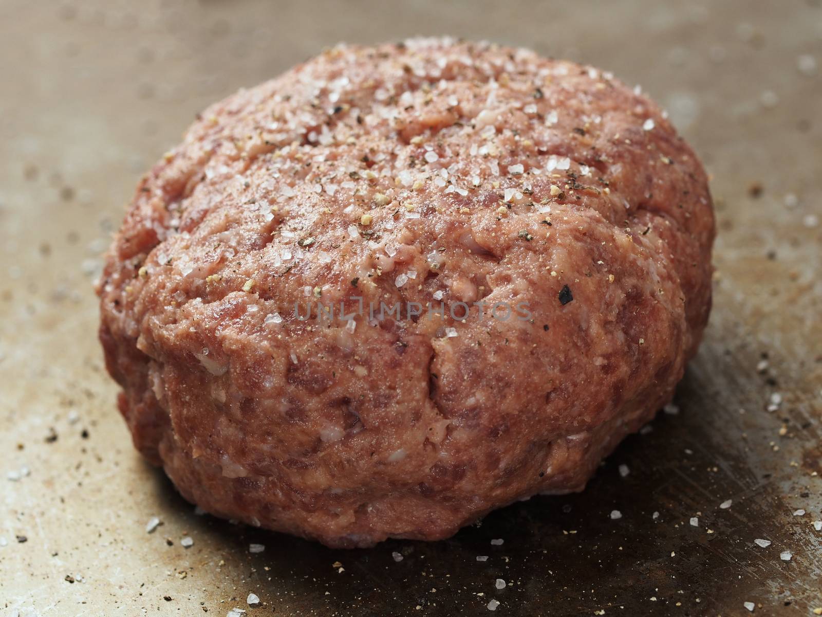 close up of rustic uncooked seasoned hamburger patty