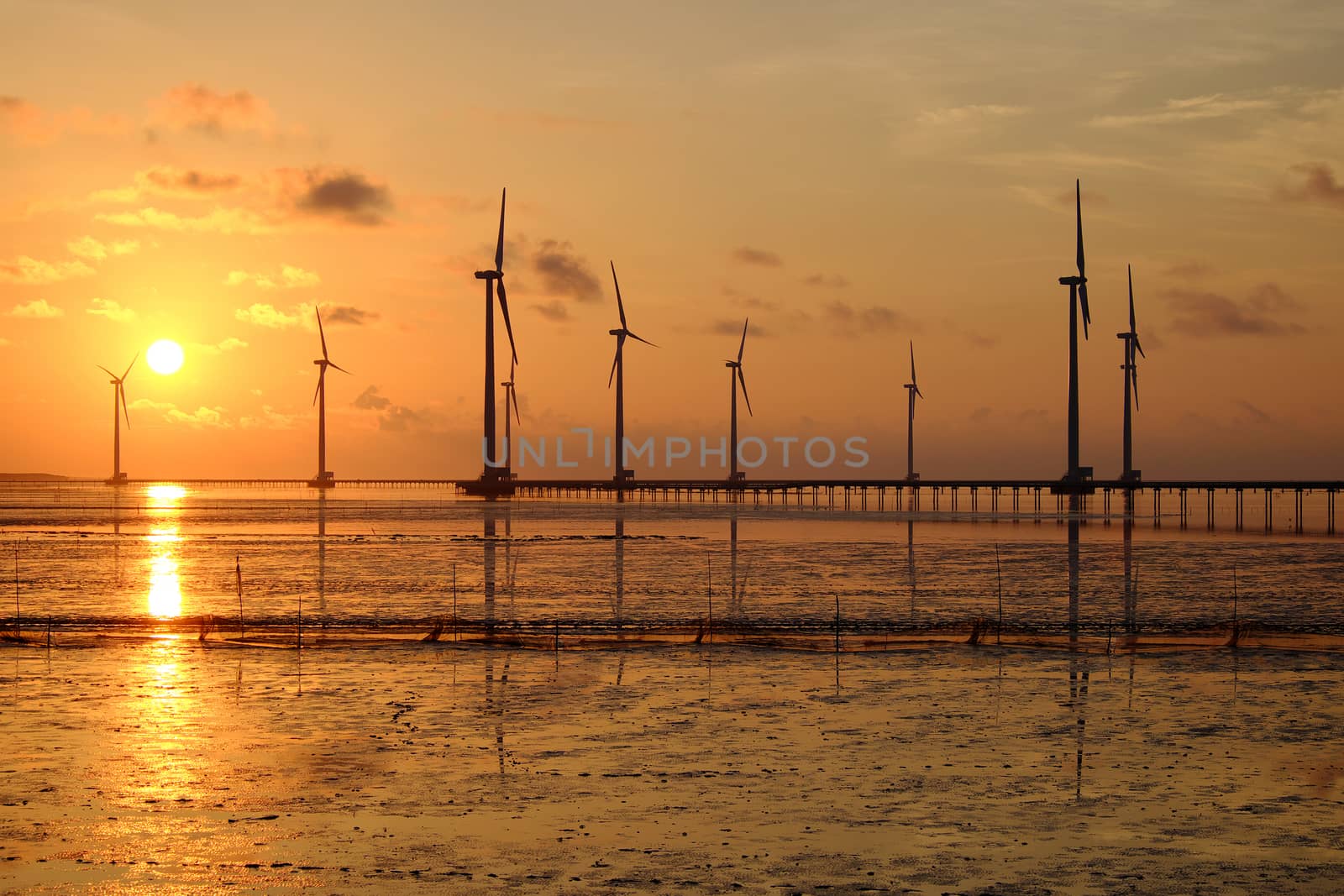 Group of wind turbines of Bac Lieu wind power plant at Mekong Delta, Vietnam. Windmill at Baclieu seaside at sunrise, make clean energy for Viet nam industry