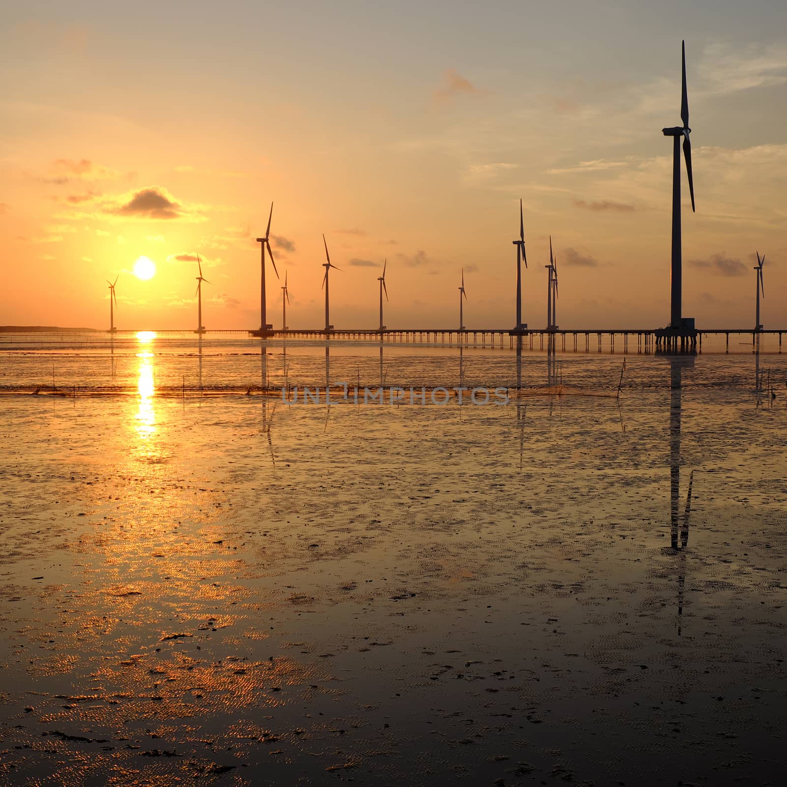 Group of wind turbines of Bac Lieu wind power plant at Mekong Delta, Vietnam. Windmill at Baclieu seaside at sunrise, make clean energy for Viet nam industry