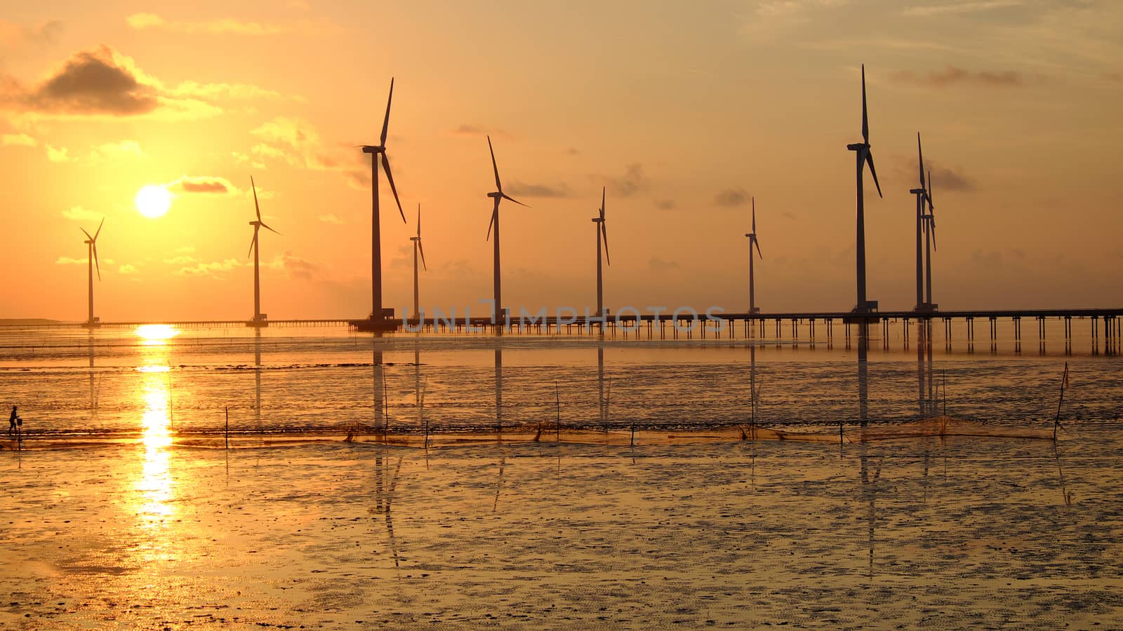 Group of wind turbines of Bac Lieu wind power plant at Mekong Delta, Vietnam. Windmill at Baclieu seaside at sunrise, make clean energy for Viet nam industry
