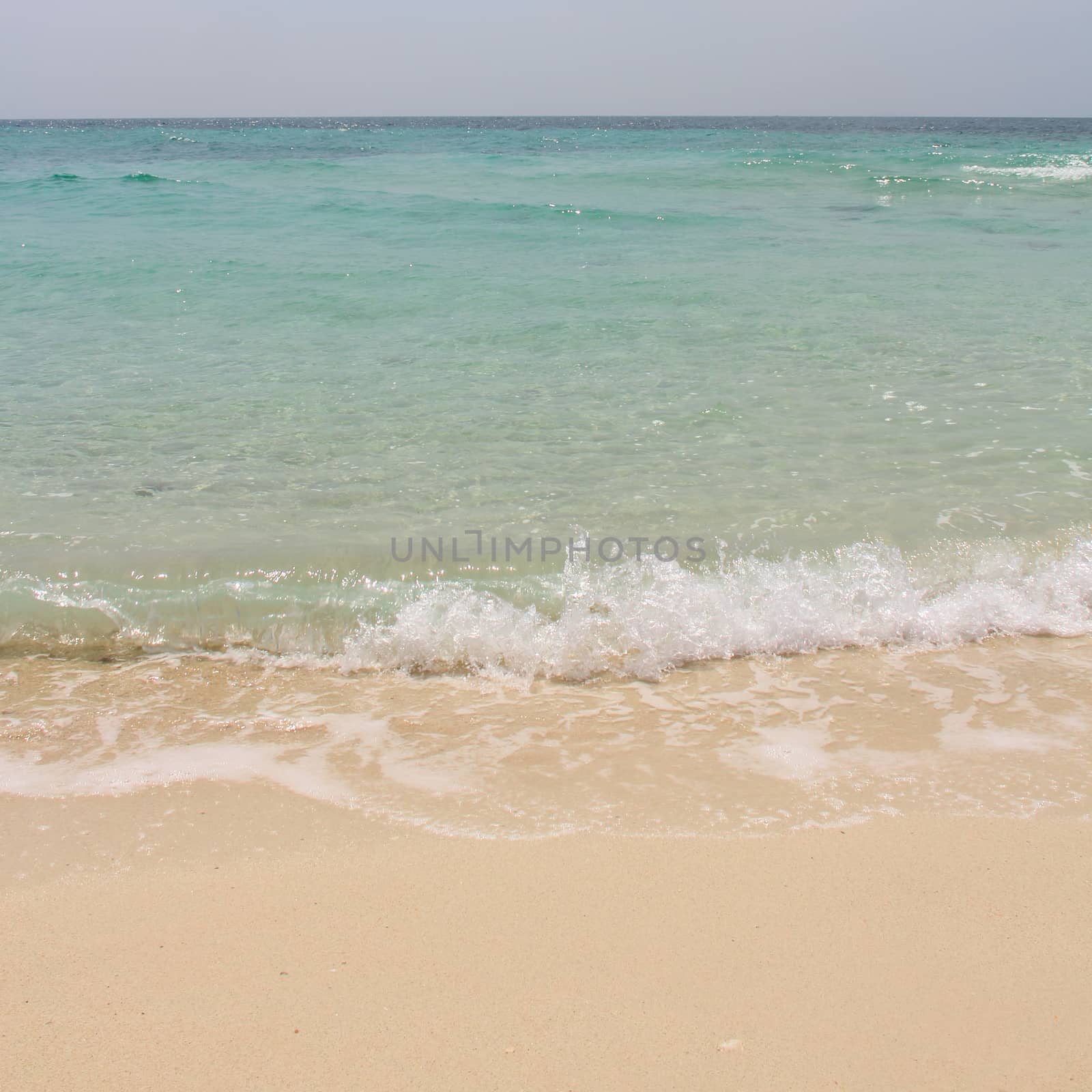 Beautiful sandy beach and transparent soft wave of blue sea, Thailand