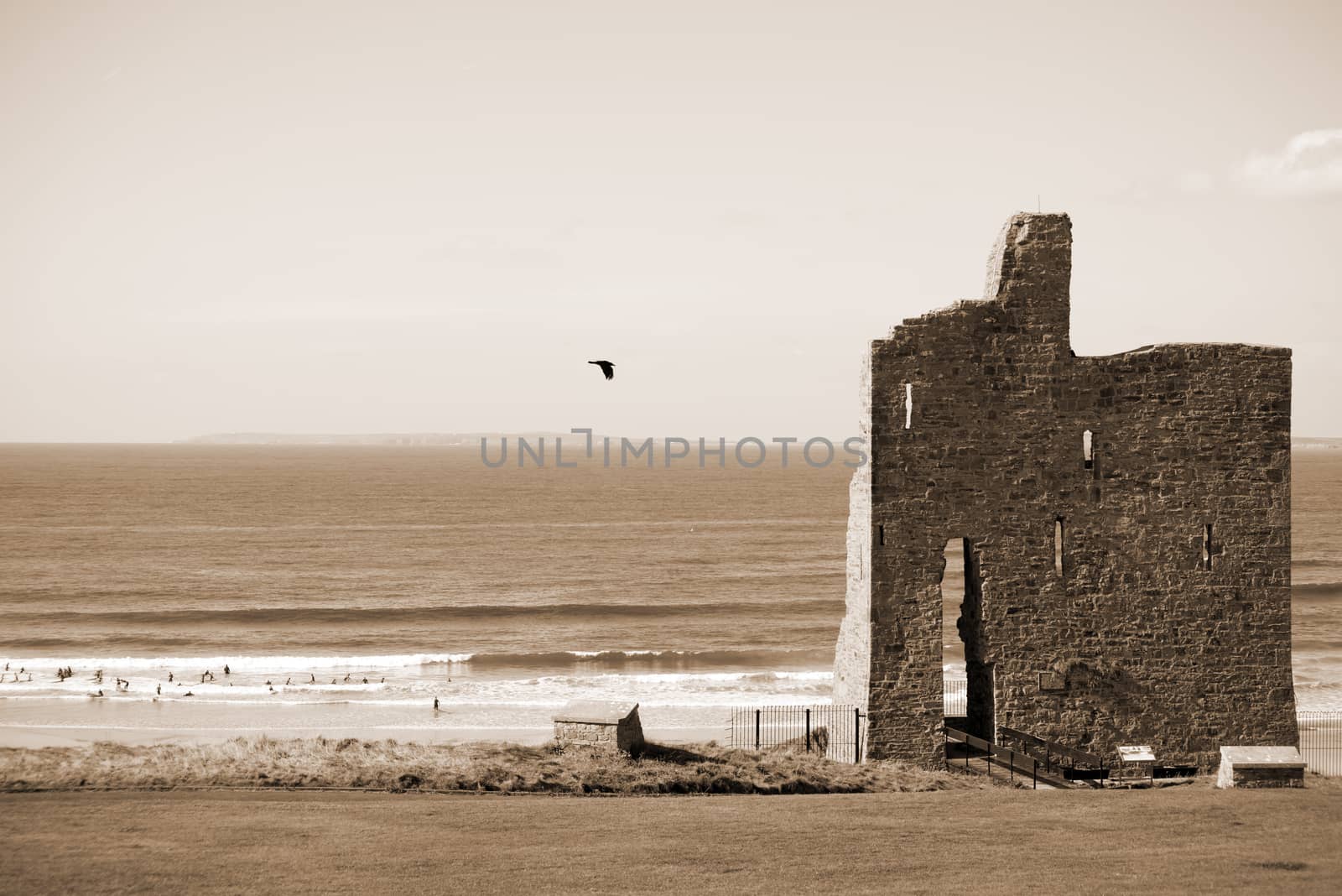 sepia ballybunion castle ruins with surfers by morrbyte