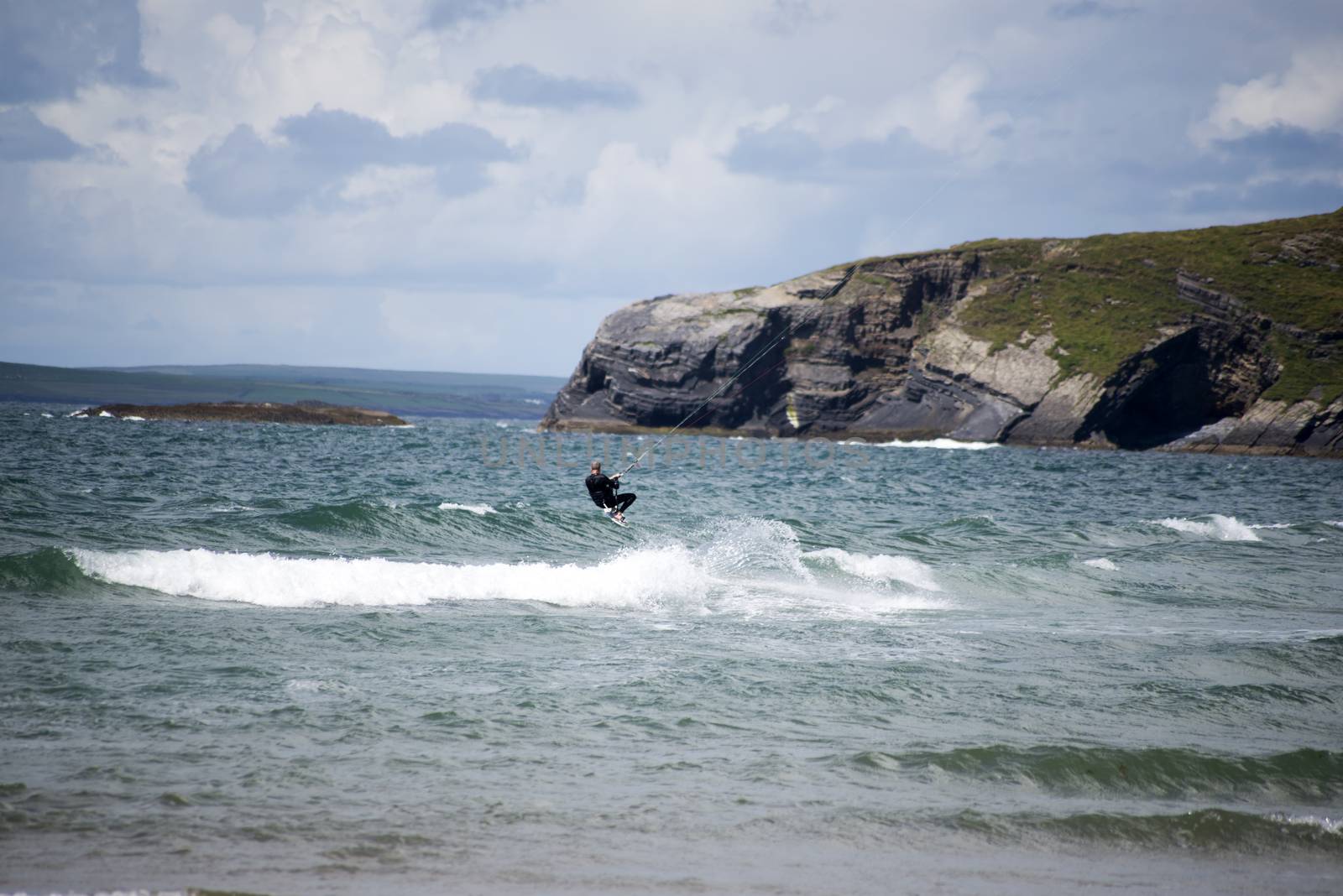 lone kite surfer surfing the waves at ballybunion beach on the wild atlantic way