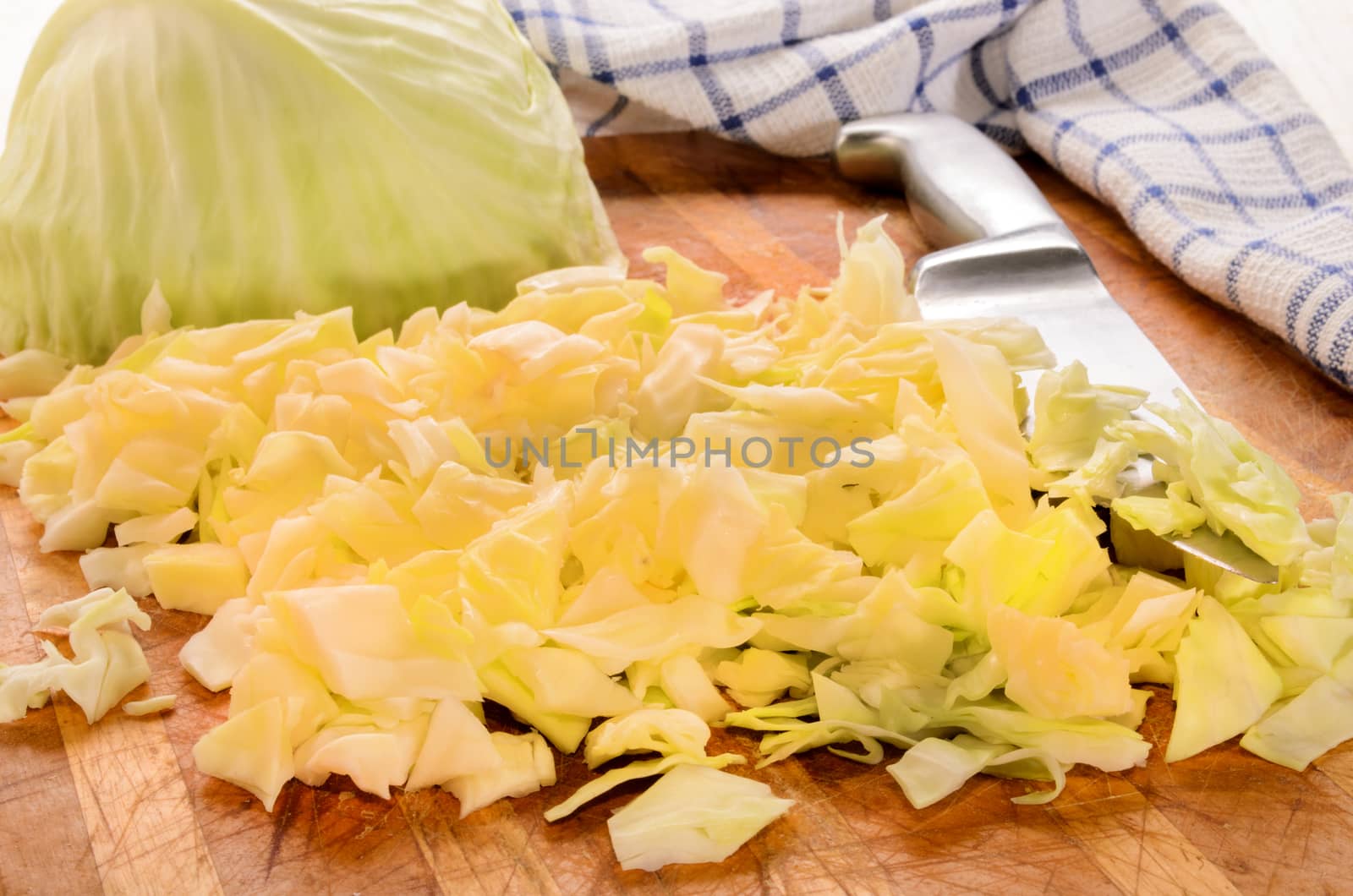 finely chopped white cabbage on a wooden board and knife