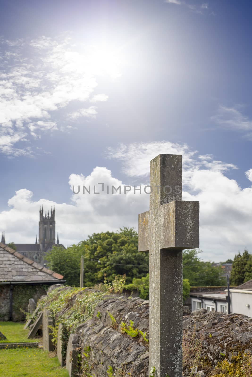 sunshine over cross at ancient graveyard in St Canice’s Cathedral in kilkenny city ireland
