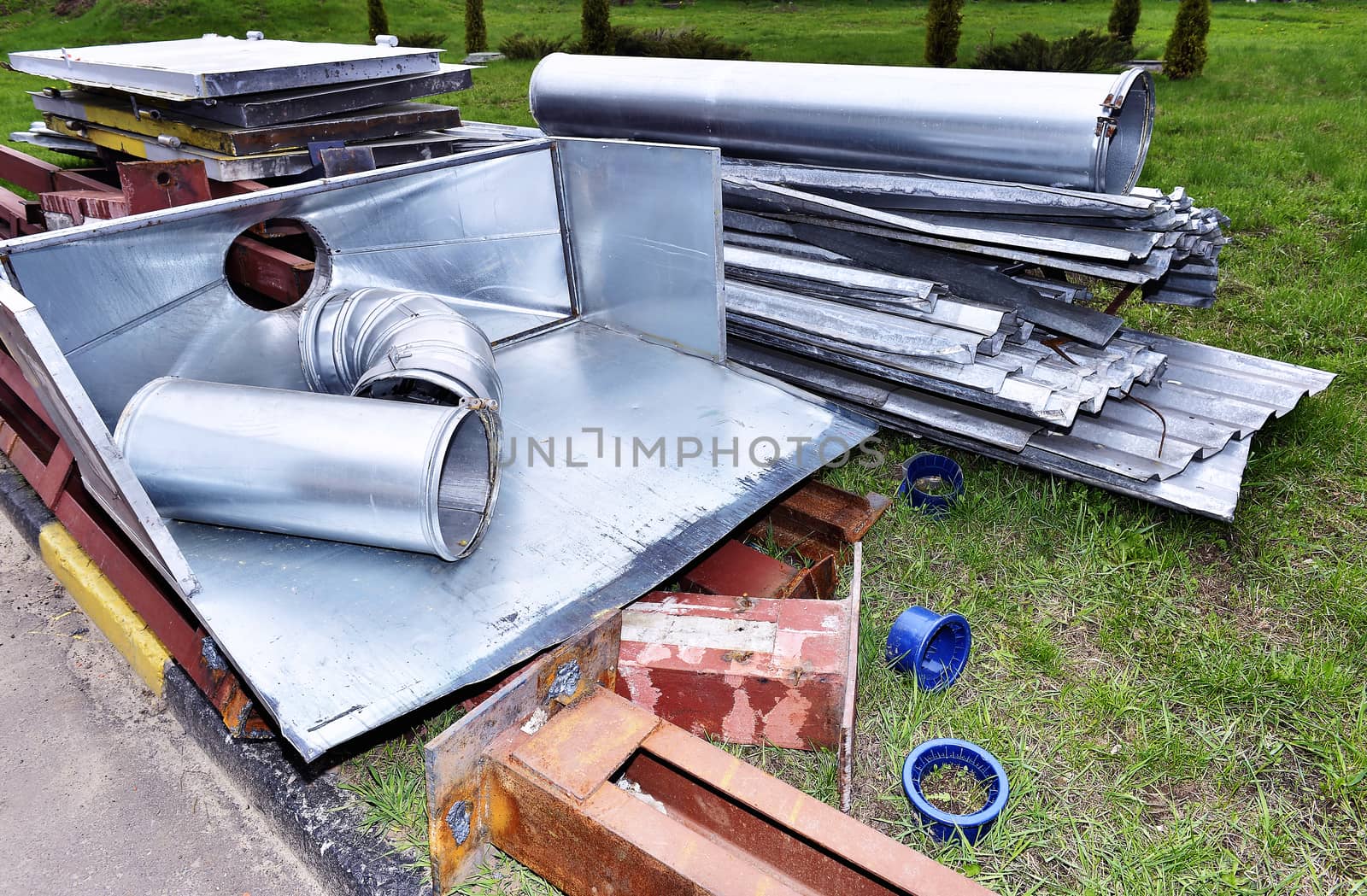 Metal parts are dismantled structures stored in the soil on the territory of industrial site.