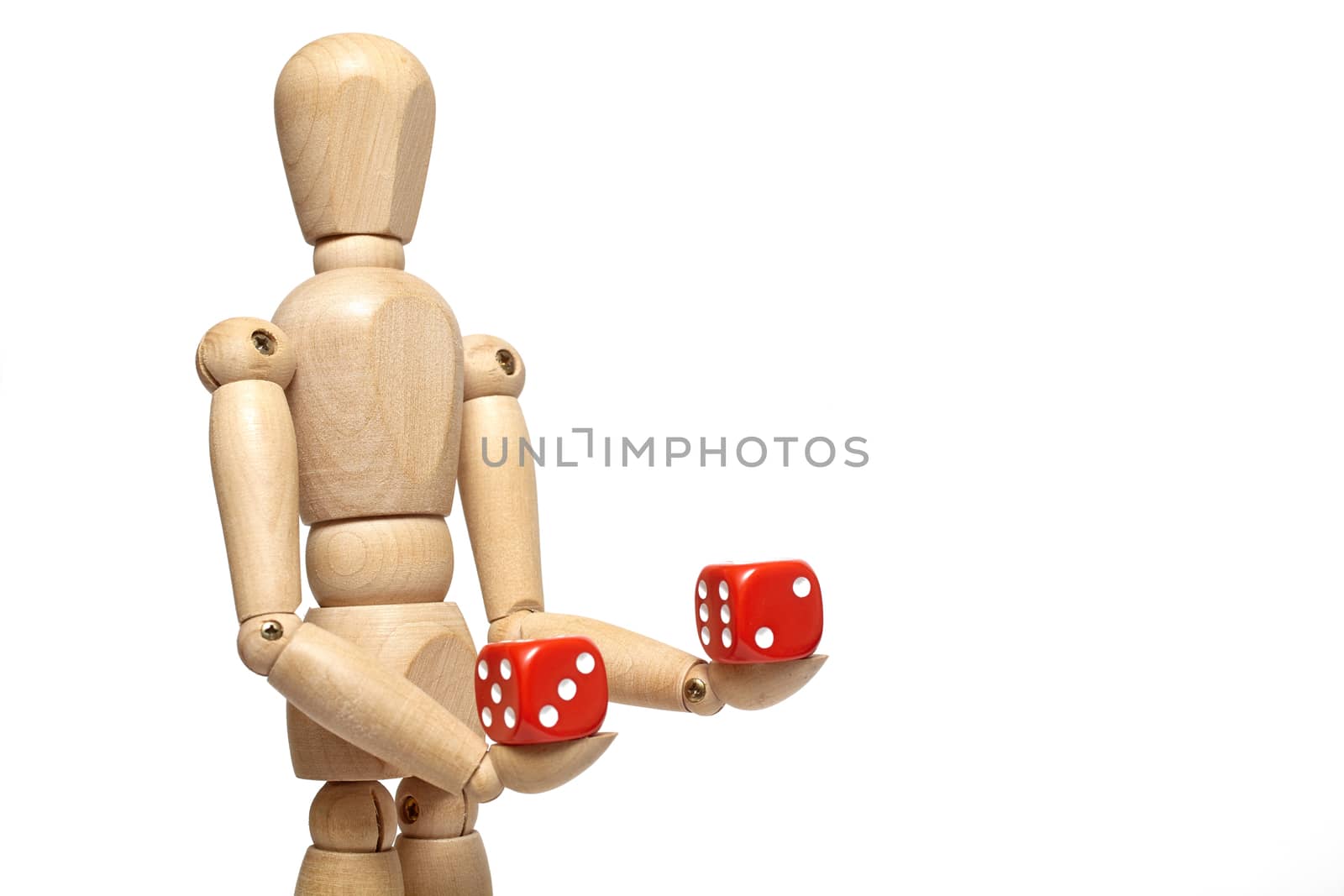 Wooden puppet holds dice on white background with clipping path