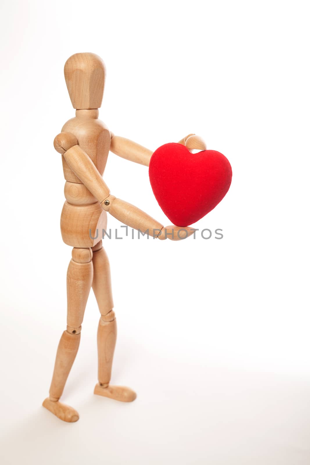 Dummy holding a red heart on white background