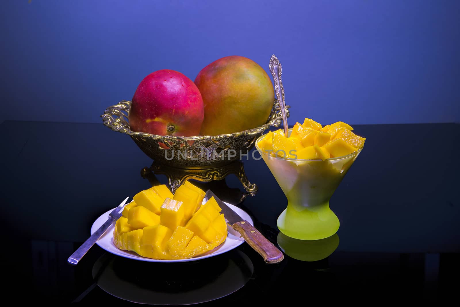 Ripe mangoes and cut into a plate and a glass