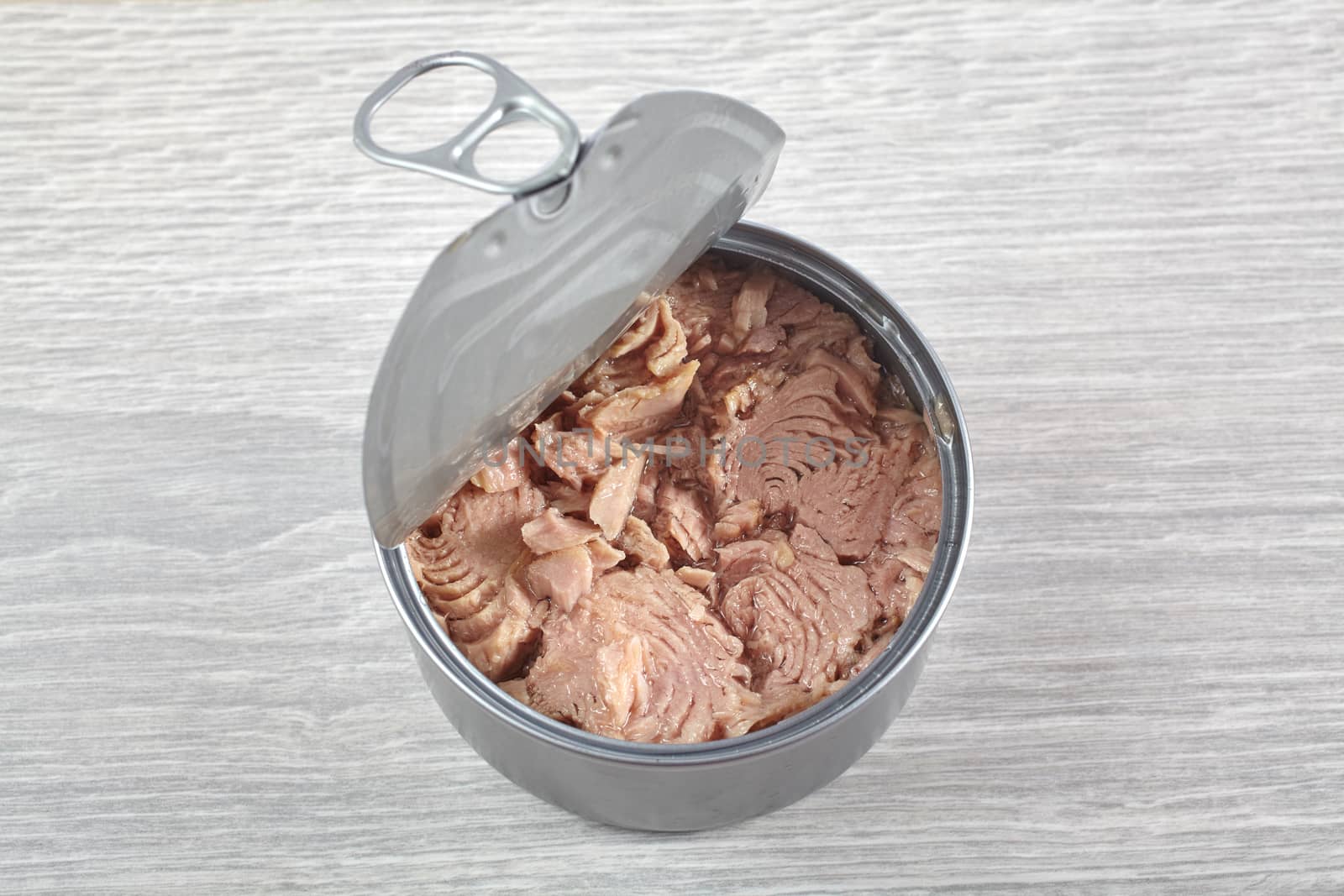 Open tuna tin on a gray background