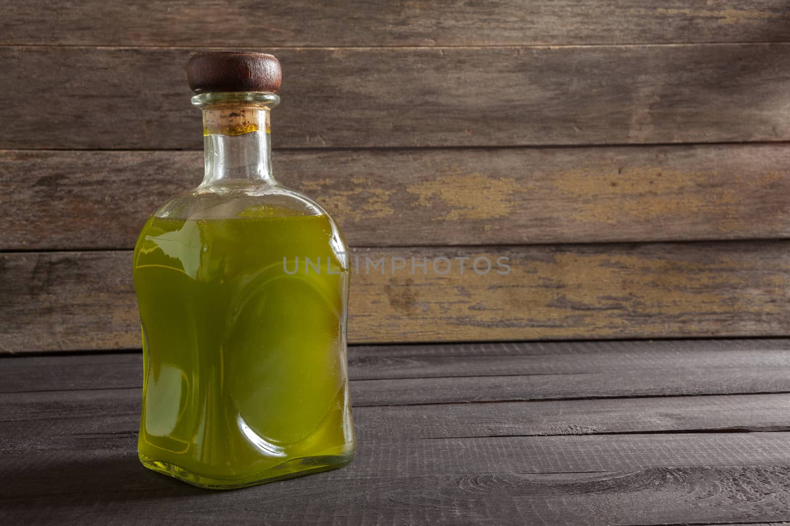 Olive oil bottle on wooden background