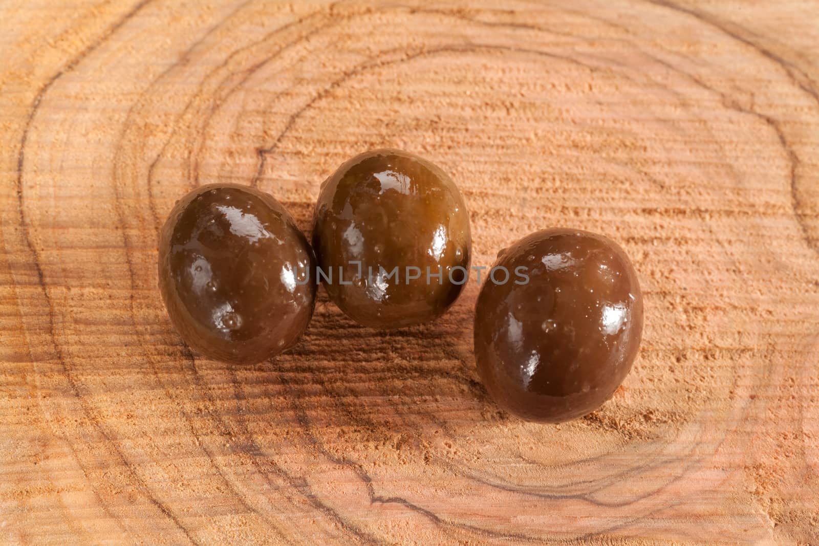 Olive wood surface with a few olives