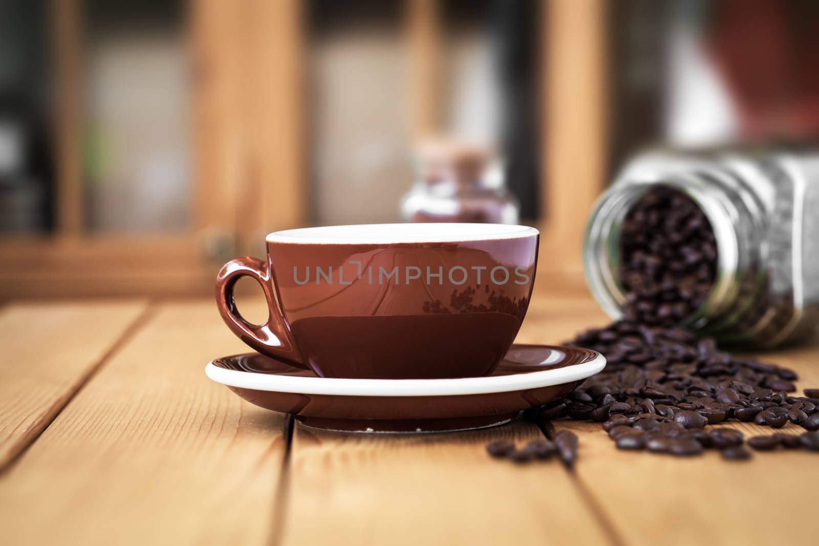 Cup coffee on a wooden table with scattered coffee beans by motorolka