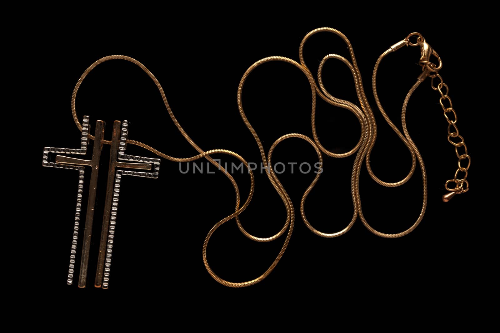 Golden chain necklace with cross on blackground