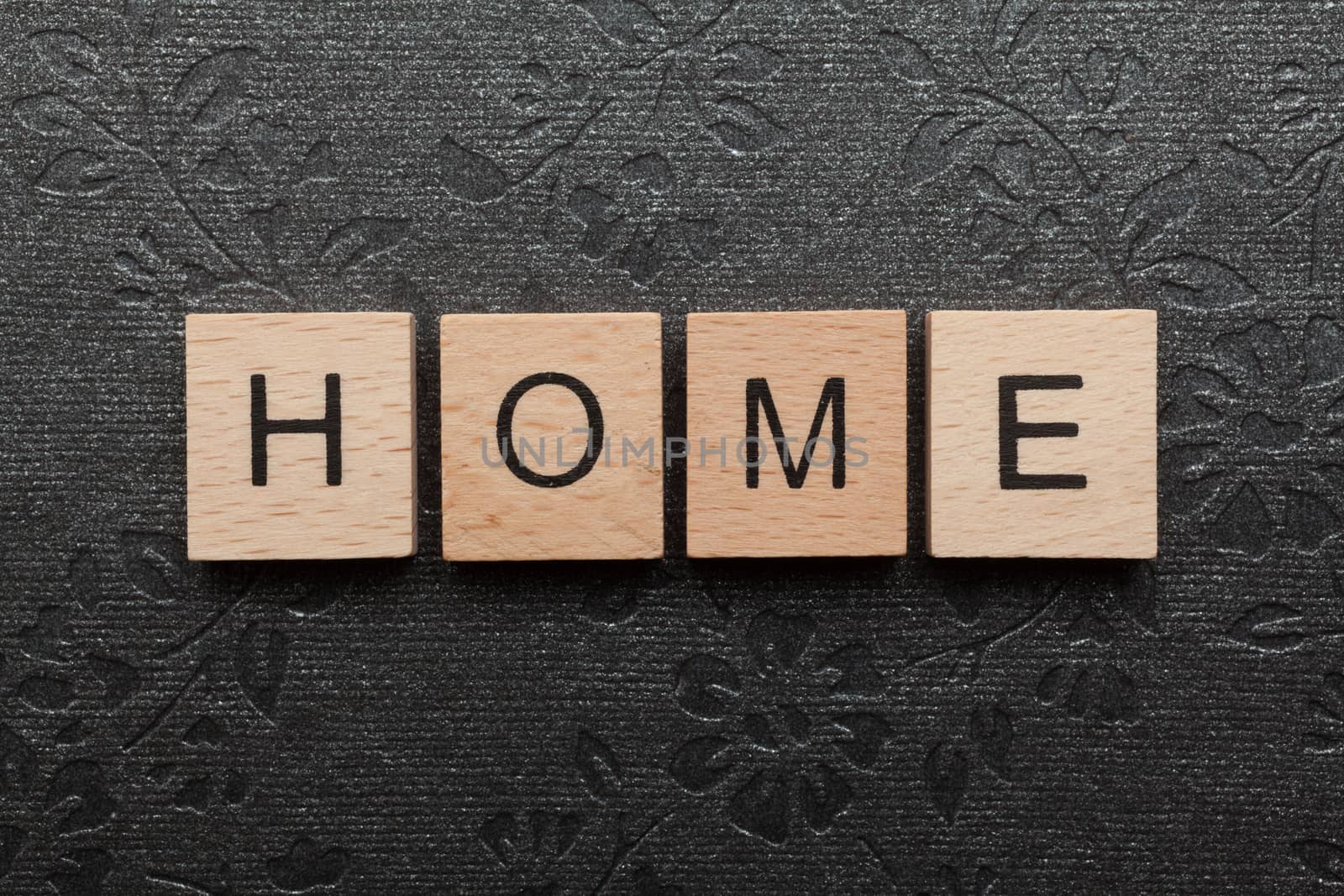 Wooden letters spelling HOME on black background