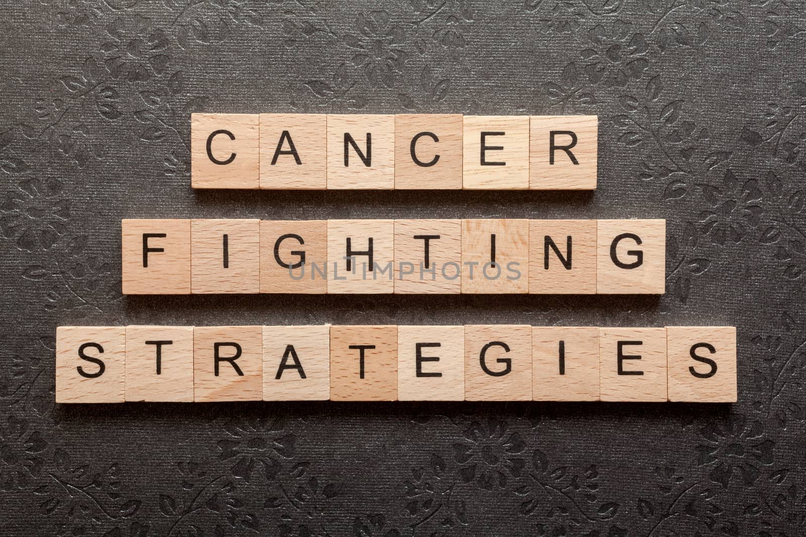 Wooden letters spelling CANCER FIGHTING STRATEGIES on black background
