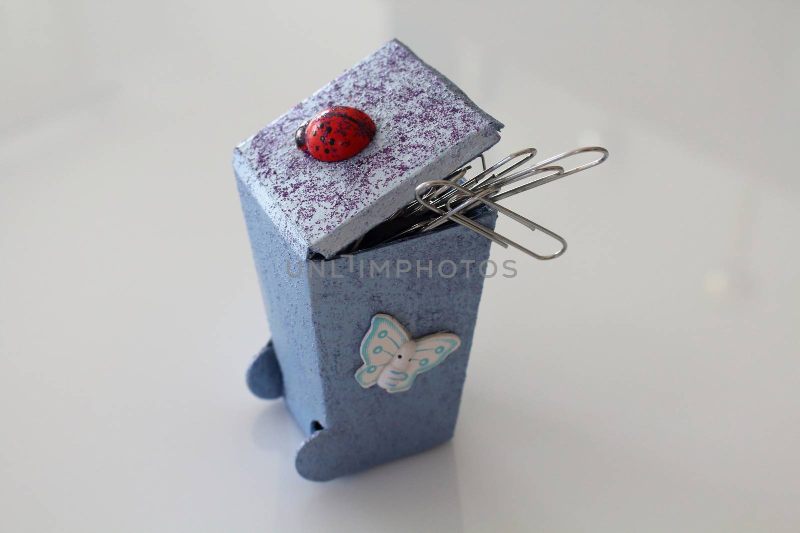 A small hand-made waste bins decoupaged with ladybug and butterfly, handmade objects decorated using different techniques of decoupage