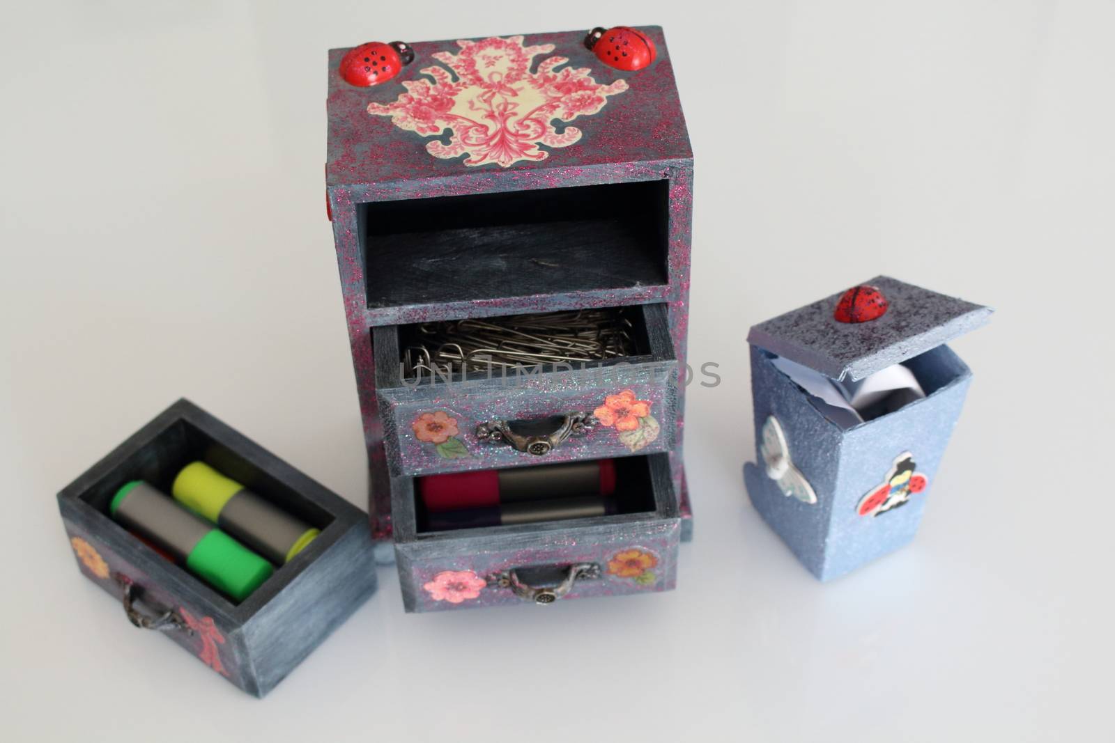 A handmade mini chest of three drawers decoupaged with floral vintage paper, handmade objects decorated using different techniques of decoupage