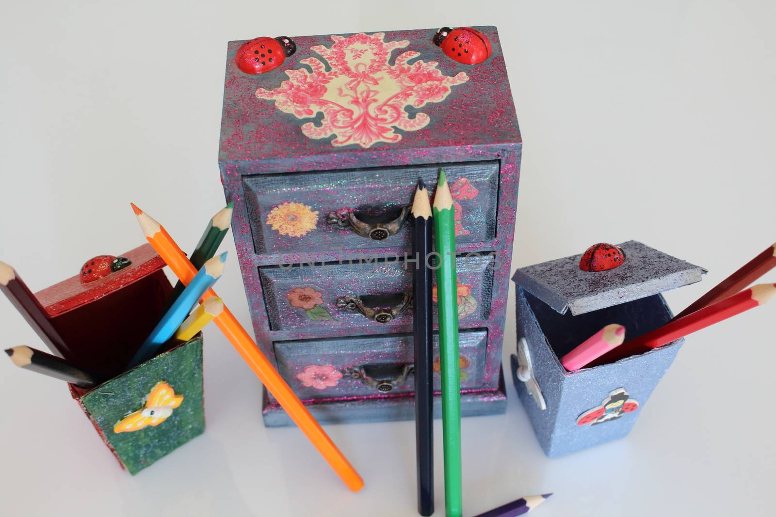 A handmade mini chest of three drawers decoupaged with floral vintage paper, handmade objects decorated using different techniques of decoupage