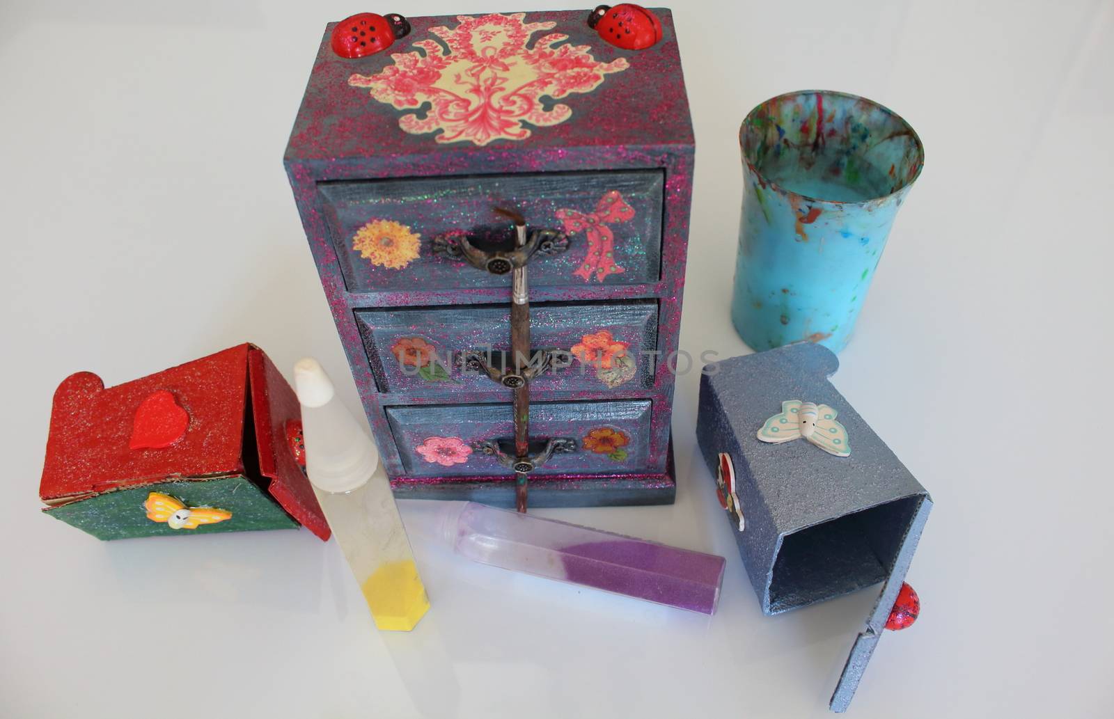 A handmade mini chest of three drawers decoupaged with floral vintage paper, handmade objects decorated using different techniques of decoupage