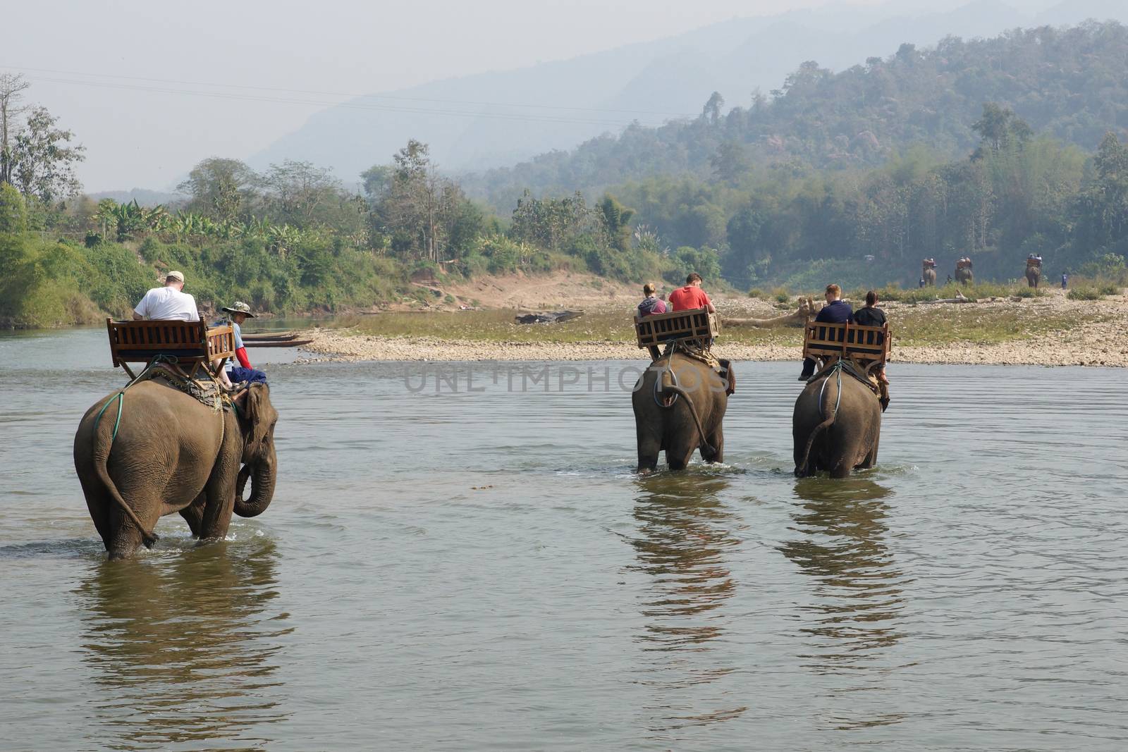 LUANG PRABANG, LAOS - FEBRUARY 12, 2016: Tourists riding elephants on February 12 in Laos, South East Asia