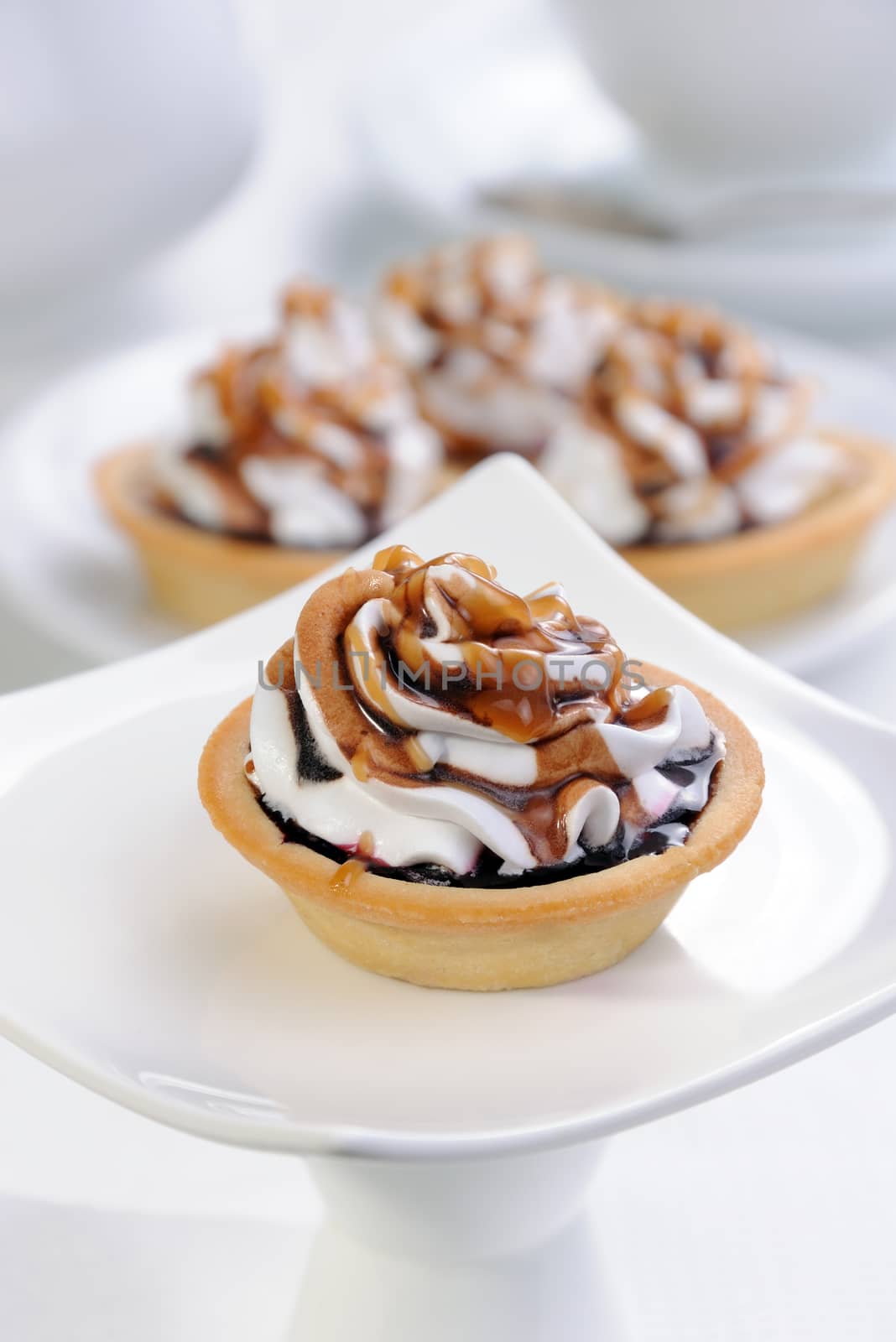 Shortbread сakes filled jam with whipped cream and chocolate, caramel topping