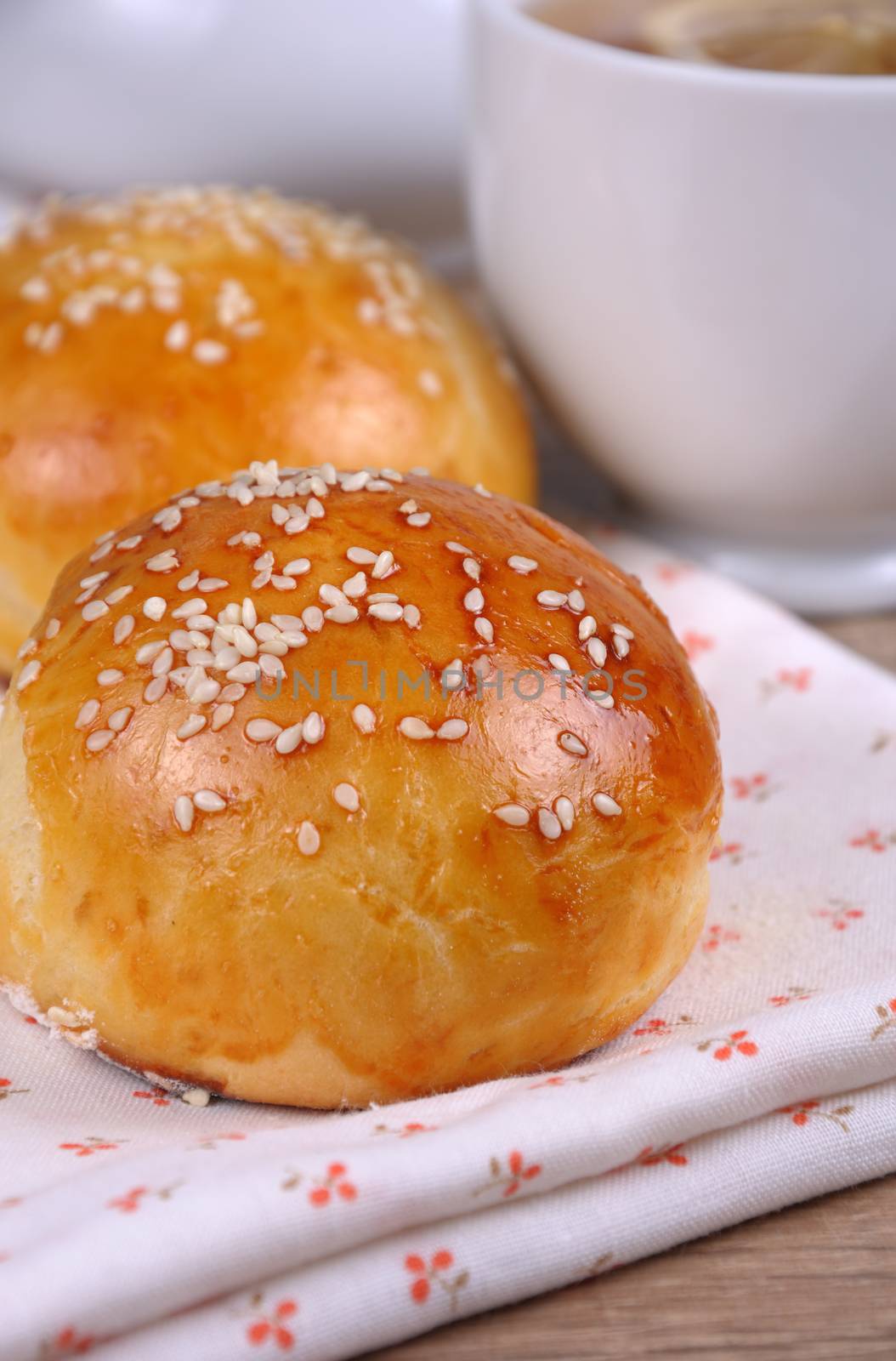 Buns with sesame seeds in a basket on table