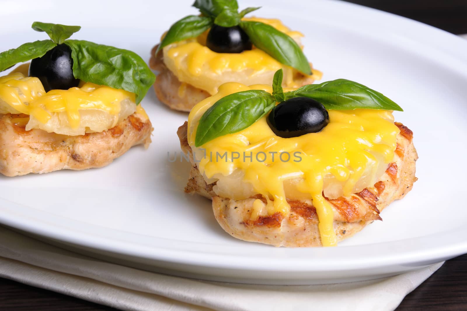 pieces of chicken fillet    a slice of pineapple with cheese