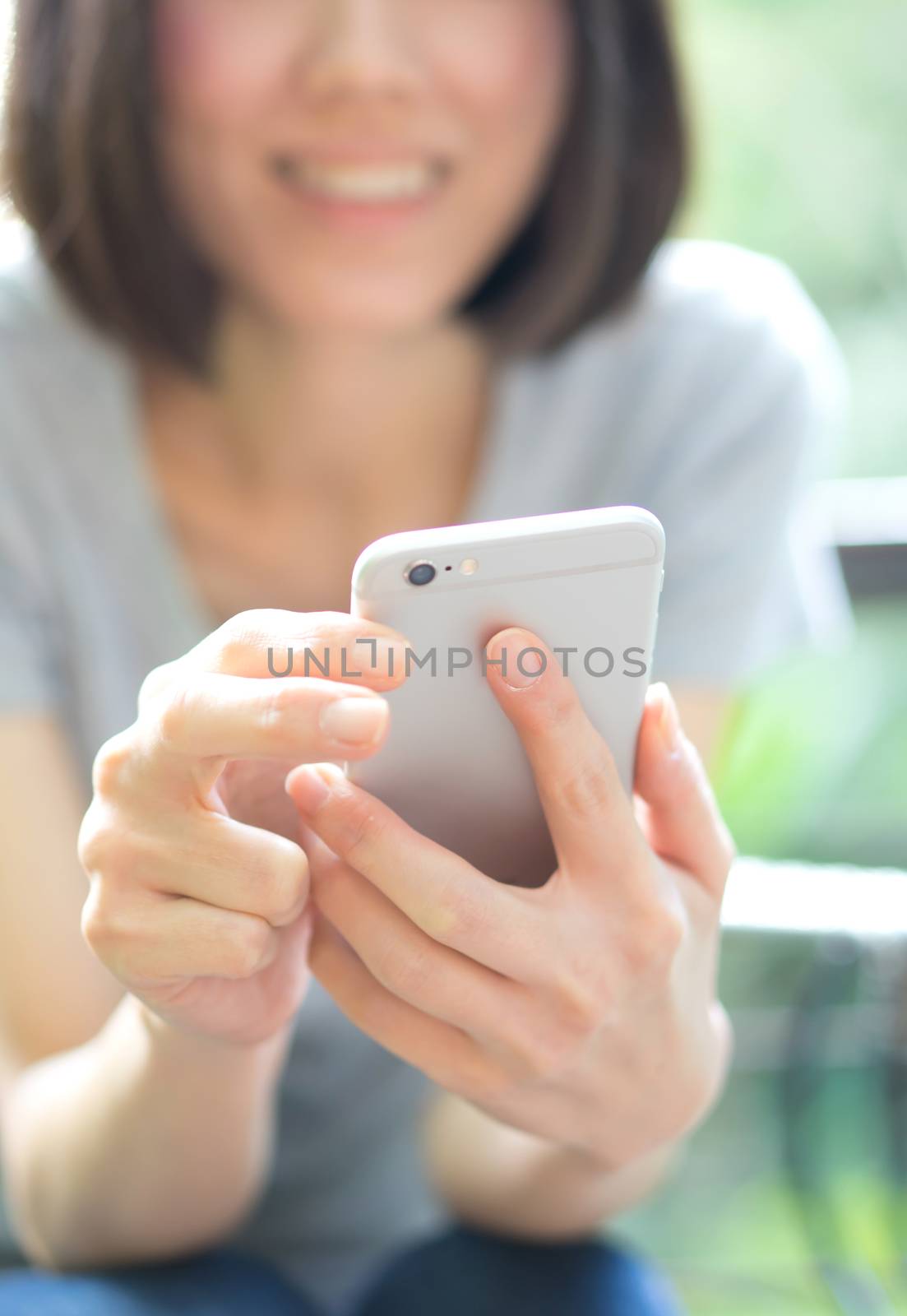  beautiful woman writes an SMS to your mobile phone by ekachailo