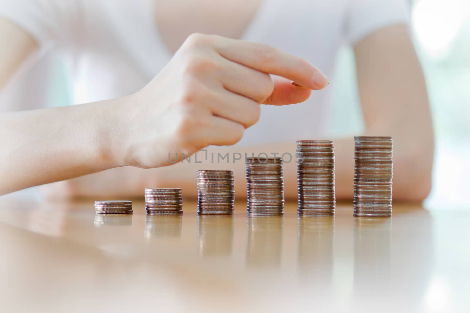 woman put coins to stack of coins