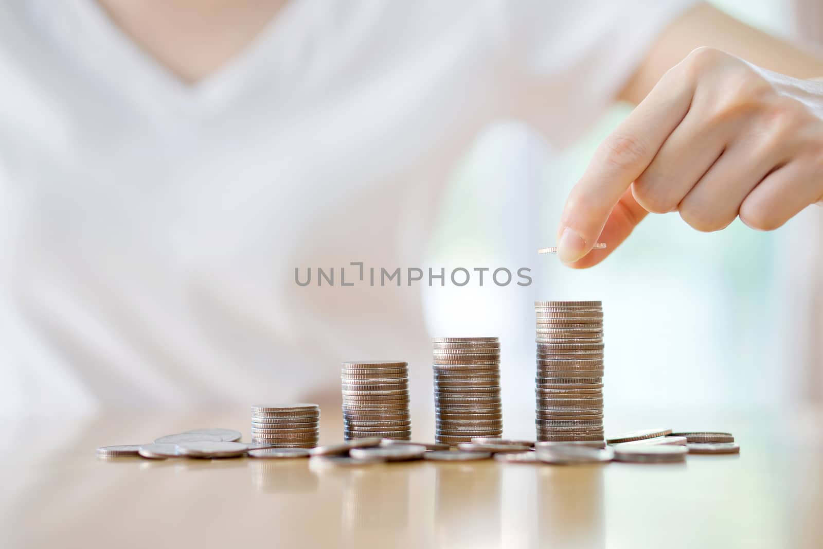 woman put coins to stack of coins