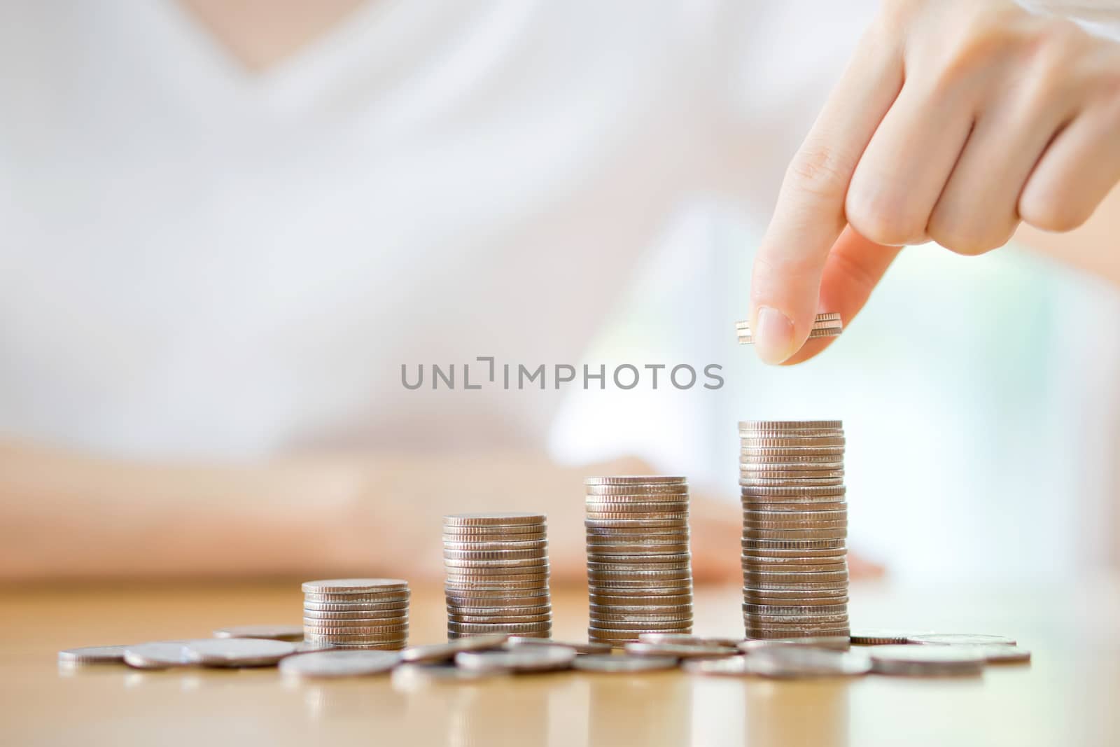 woman put coins to stack of coins