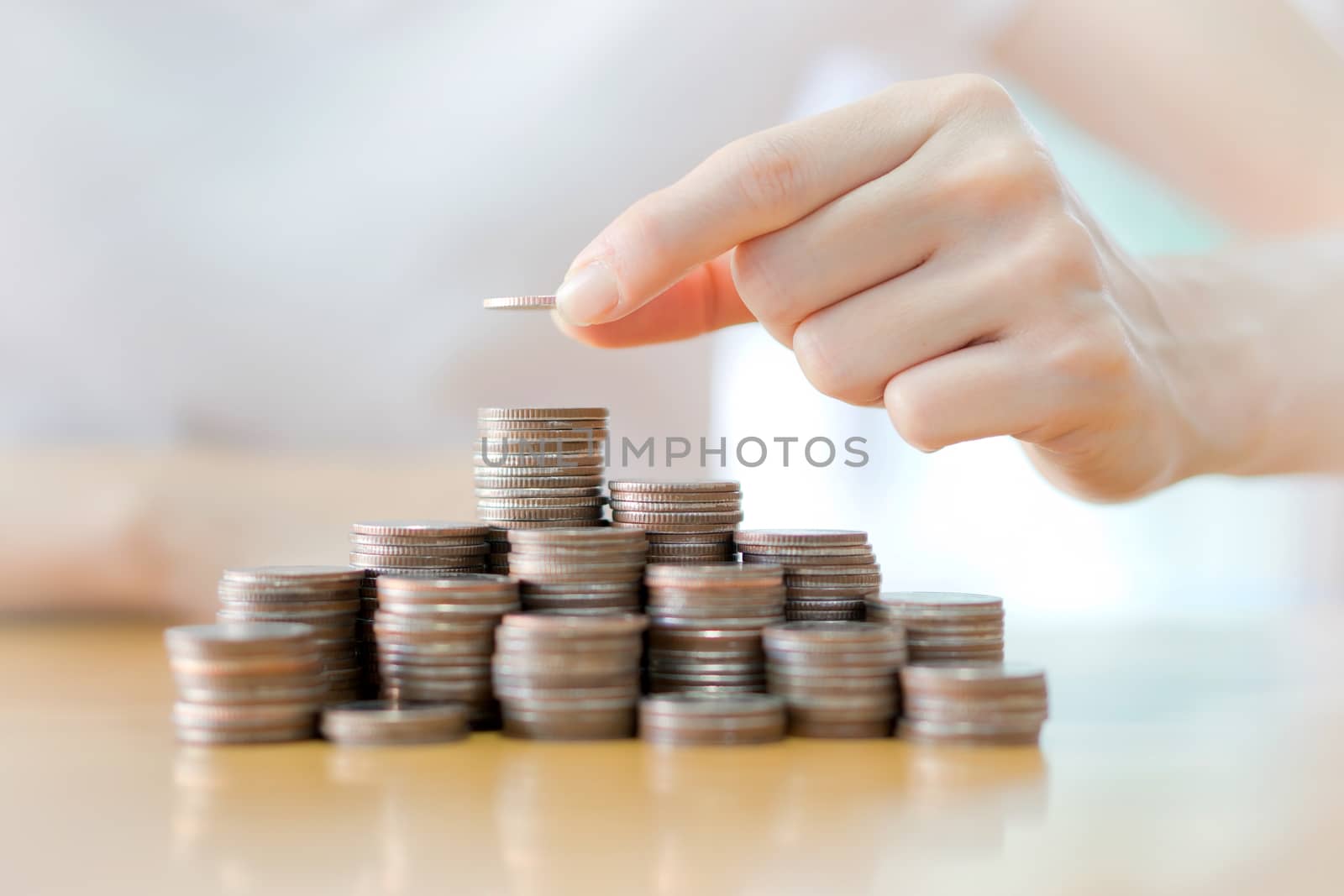 Hand put coins to stack of coins