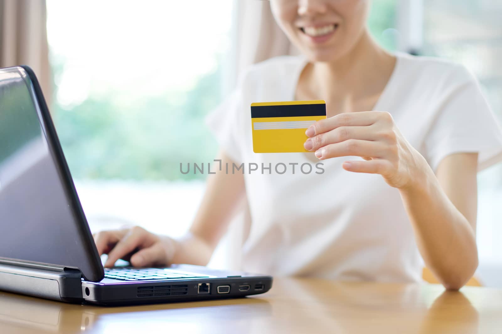 Close Up Of A female Shopping Online Using Laptop With Credit Ca by ekachailo