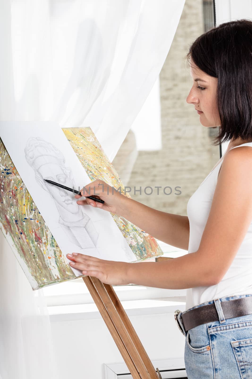 young woman with an easel paints a picture