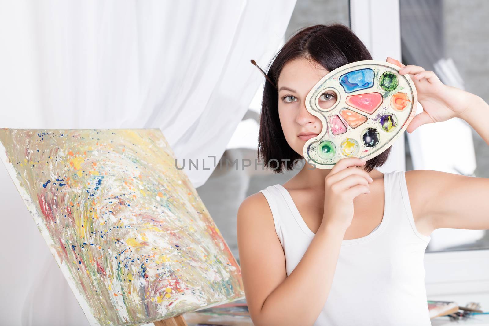 young woman with an easel paints a picture