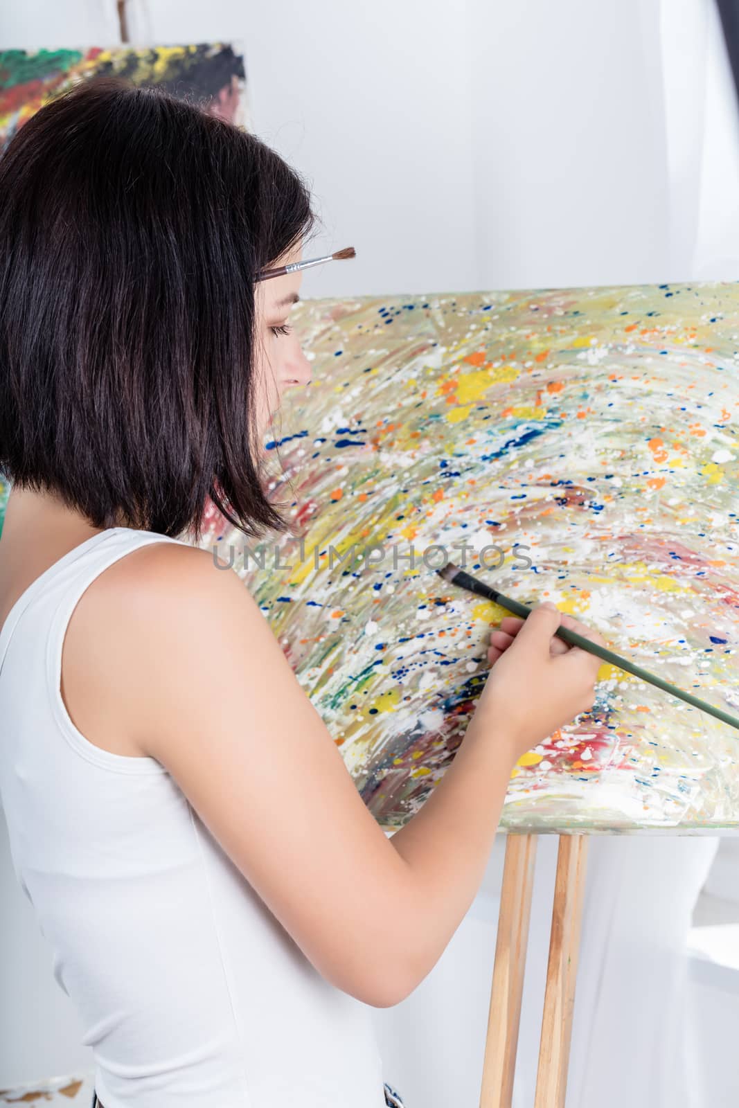 young woman with an easel paints a picture