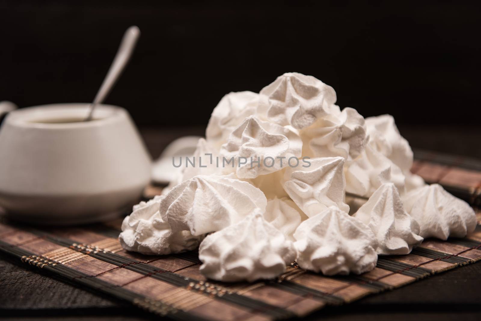 bizet on a brown wooden table with a cup of tea, sugar and milk