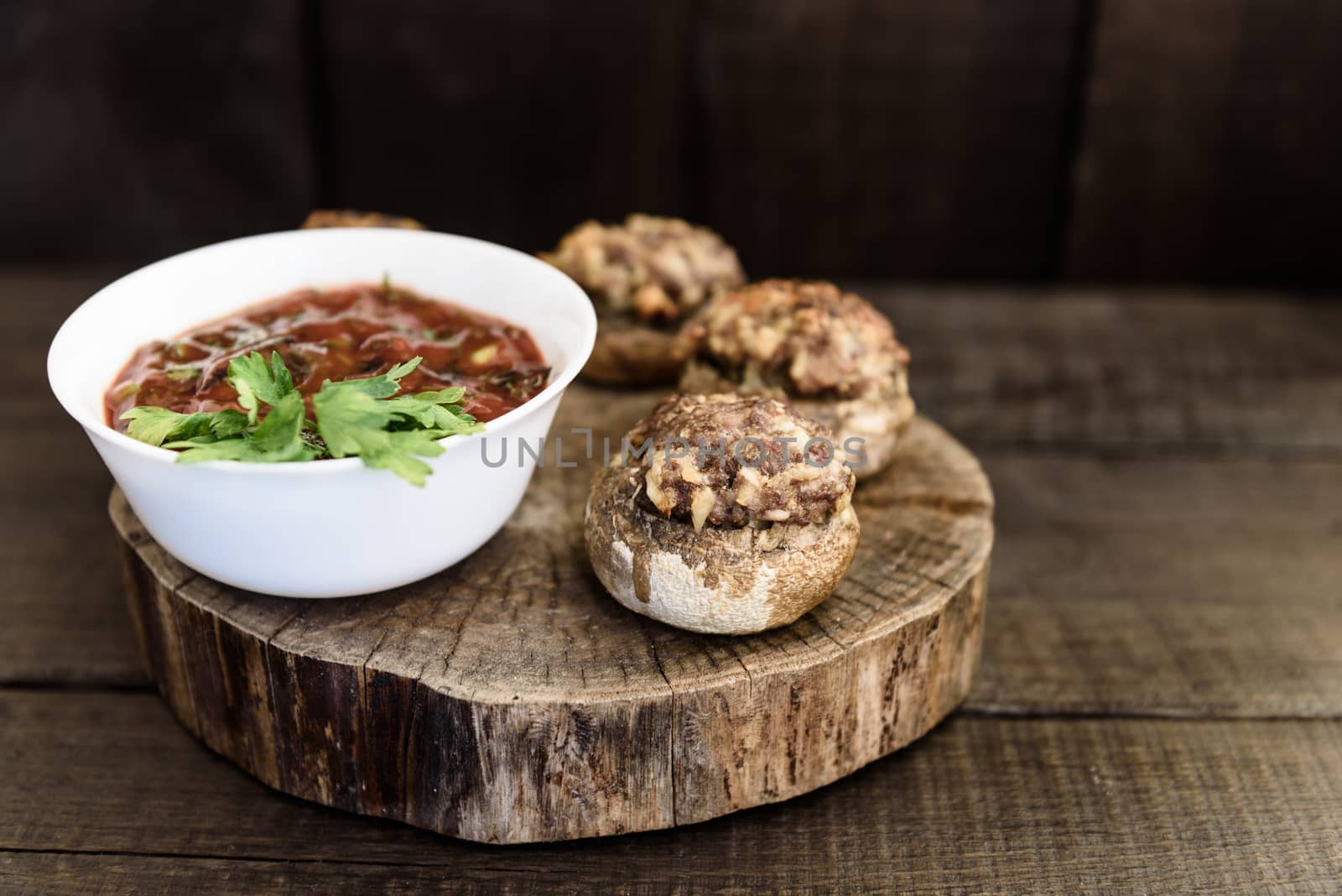 baked mushrooms with meat and sauce on a wood