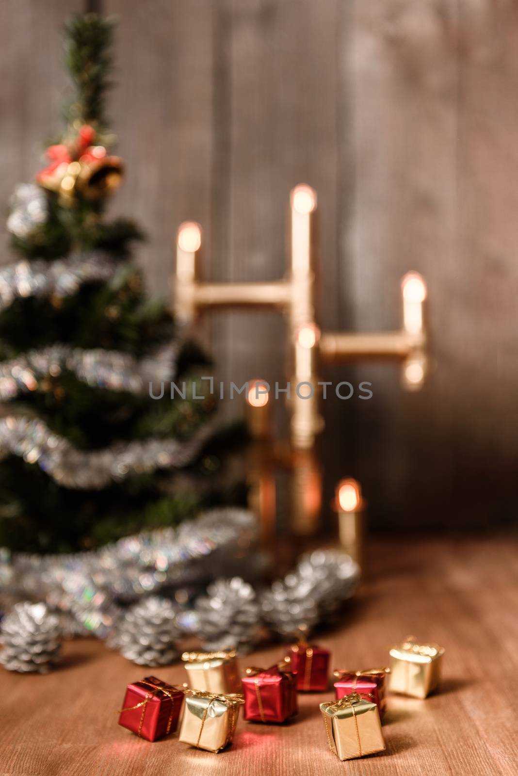 Christmas decorative tree is adorned with rain stands on the table with a lit lamp lights
